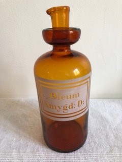 Un vieux flacon pharmacologique en verre marron a une inscription latine sur fond blanc