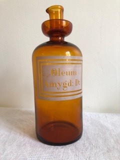 Un vieux flacon pharmacologique en verre marron a une inscription latine sur fond blanc